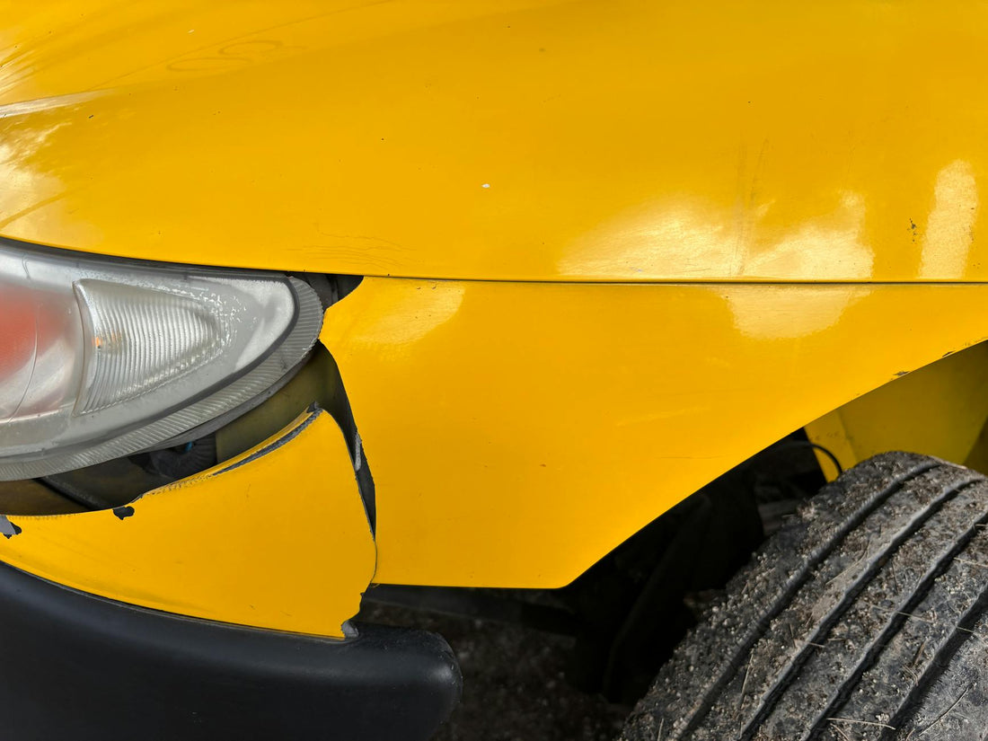 Scratched yellow car bumper with paint transfer and scuffs